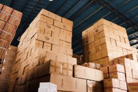 Organização de armazém com caixas empilhadas e controle de estoque eficiente