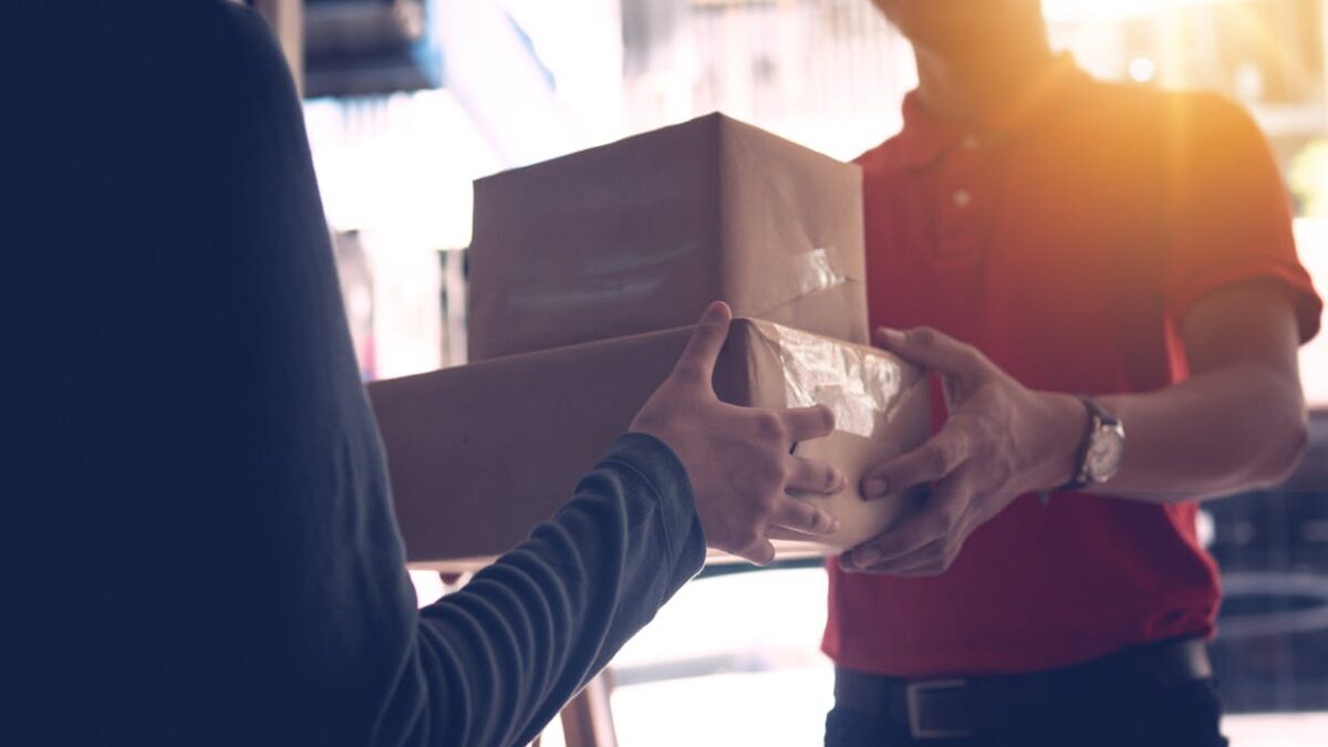 Entrega de encomenda entre duas pessoas representando logística eficiente e redução de custos de transporte